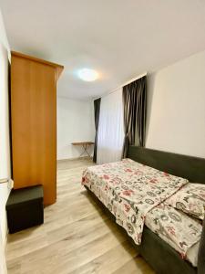 een kleine slaapkamer met een bed en een deur bij Mainstreet Apartments Suceava in Suceava