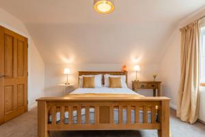 een slaapkamer met een groot bed en 2 lampen bij Alnwood in Chesters