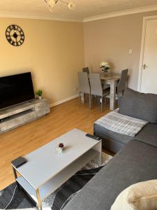 a living room with a couch and a table at Stylish 2 Bedroom Home In Essex in Basildon