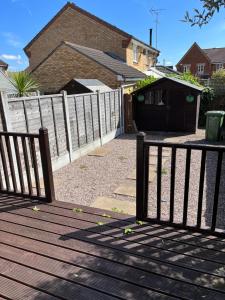 a wooden deck with a fence in front of a house at Stylish 2 Bedroom Home In Essex in Basildon