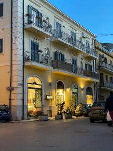 un edificio con balconi e auto parcheggiate di fronte ad esso di Flat44 a Palermo