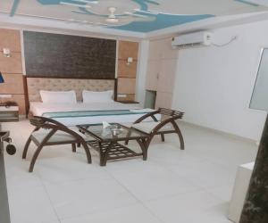 Cette chambre comprend un lit, une table et un canapé. dans l'établissement Hotel ALVAA GRAND Near Delhi Airport BY-AERO HOME STAY, à New Delhi