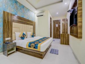 um quarto com uma cama grande e uma televisão em Hotel ALVAA GRAND Near Delhi Airport BY-AERO HOME STAY em Nova Deli