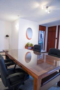 una sala conferenze con tavolo e sedie in legno di HOSTAL CHOCOLATE CALENDA a Città di Oaxaca