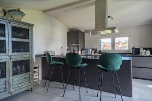 uma cozinha com bancos verdes num balcão em Casa Grotti: Charm & Comfort vicino al Mare em Capezzano Pianore,