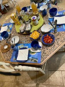 a table with blue and white plates and food on it at La Maison du Canal de Rompsay - 5 min de la Rochelle in Périgny