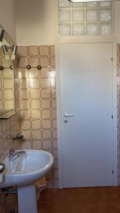 La salle de bains est pourvue d'une porte blanche et d'un lavabo. dans l'établissement SoleMare, à Bellaria-Igea Marina