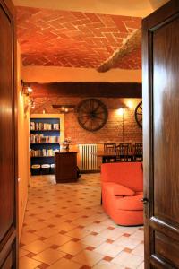 een woonkamer met een rode bank en een bibliotheek bij Monferrato AgriCottage Valentina in Calliano