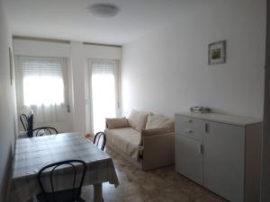 a living room with a couch and a table at Comodo appartamento a pochi metri dal mare in Bibione +2 photos