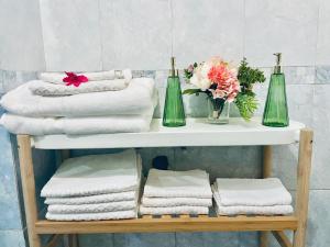 a white shelf with towels and two green bottles at JCK Tuscany Apartment in Livorno +113 photos