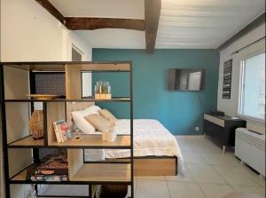 a bedroom with a bed and a blue wall at Le Viala, Studio dans le centre historique de Hyères in Hyères