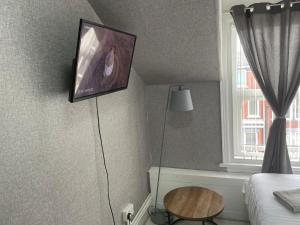 a bedroom with a tv on the wall and a table at Mr sandman’s hotel in Blackpool