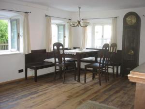 une salle à manger avec une table, des chaises et une horloge dans l'établissement "Zum Kirchenschuster", à Schernfeld