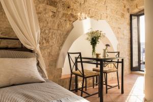 a bedroom with a table with two chairs and a bed at La Torre Storica in Bitonto