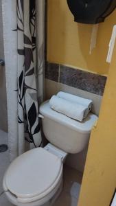 Łazienka z białą toaletą i zasłoną prysznicową w obiekcie NovHotel w mieście Comalcalco