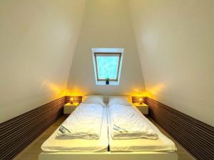 Cama en habitación con ventana y luces en Strandgut Comfortable holiday residence, en Heiligenhafen