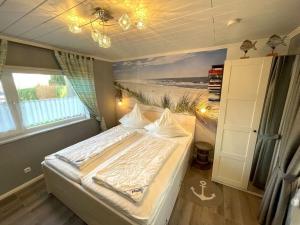 een slaapkamer met een bed en een schilderij van een strand bij Villa Hügel Comfortable holiday residence in Heiligenhafen