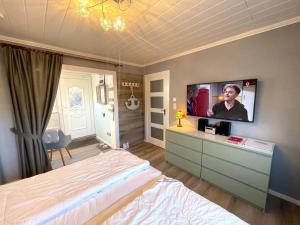 een slaapkamer met een bed en een tv aan de muur bij Villa Hügel Comfortable holiday residence in Heiligenhafen