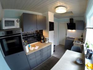 een keuken met grijze kasten en een fornuis met oven bij Villa Hügel Comfortable holiday residence in Heiligenhafen
