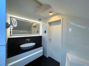 Un baño blanco con lavabo y espejo. en My holiday home Zanzibar, en Hohwacht 33 fotos más