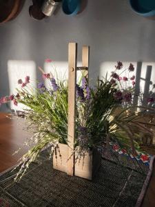 ein Blumenarrangement in einer Holzkiste auf einem Tisch in der Unterkunft Agriturismo Is Conchisceddas in Gonnosfanàdiga