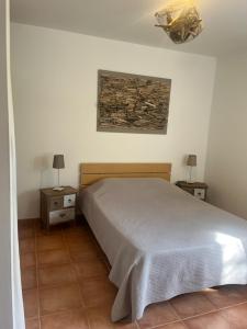 a bedroom with a bed and two night stands with lamps at Les Oliviers CENTURI-PORT in Centuri
