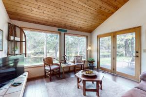 a living room with a table and chairs and windows at Golden Eagle Lane 17 | Discover Sunriver in Sunriver