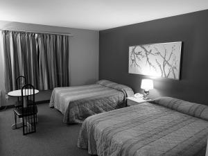 ein Hotelzimmer mit 2 Betten und einem Tisch in der Unterkunft Hôtel Saint-Côme in Saint Come
