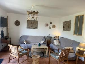 a living room with a couch and chairs and a table at Les Oliviers CENTURI-PORT in Centuri