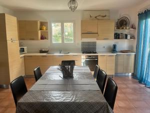 a kitchen with a table and chairs and a table and a kitchen at Les Oliviers CENTURI-PORT in Centuri