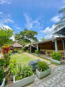 a courtyard of a house with tables and plants at Coron Vista Lodge in Coron