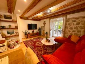 een woonkamer met een rode bank en een tafel bij Holiday Home Nautica in Kotor