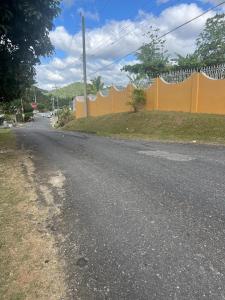 uma estrada vazia com uma cerca laranja na lateral em Cockpit County Mountain Room em Kupuis