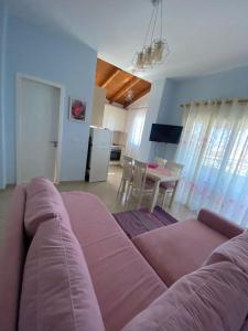 een woonkamer met een grote bank en een tafel bij Inara's apartment in Sarandë