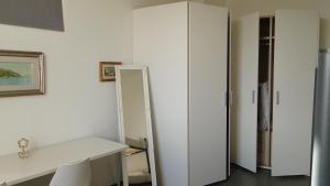 a room with a white desk and a closet at Il Pescemagra HostelAmeglia in Ameglia