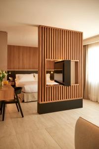Habitación de hotel con cama y TV en la pared en Lastarria Hotel, en Santiago
