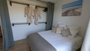 ein Schlafzimmer mit einem Bett und Mänteln, die an der Wand hängen in der Unterkunft Chambre L à Tavel in Tavel