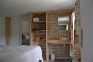 een slaapkamer met een wastafel in een bakstenen muur bij Le Petit Papillon in Durbuy