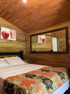 a bedroom with a bed and two pictures of apples on the wall at Cabañas el Portal in Santa Rosa de Cabal