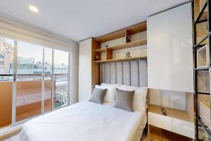 een slaapkamer met een bed en een groot raam bij gAº Ideal apartamento en Cabrera in Bogota
