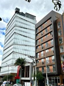 een hoog gebouw met een palmboom ervoor bij gAº Ideal apartamento en Cabrera in Bogota