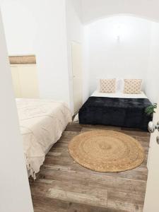 a room with two beds and a rug on the floor at Encantador T1 Coração de Évora in Évora