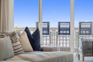 sala de estar con sofá y balcón con sillas en D22 - SeaLuxe, en Oceanside