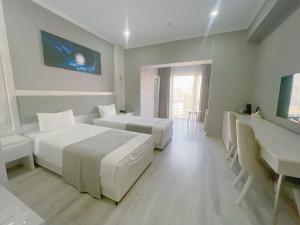 een slaapkamer met 2 bedden, een bureau en een wastafel bij Moffah Grand Hotel 美华酒店 in Tasjkent