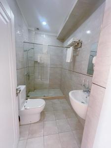 een badkamer met een douche, een toilet en een wastafel bij Moffah Grand Hotel 美华酒店 in Tasjkent