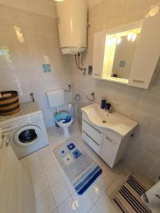 a white bathroom with a sink and a toilet at APARTMAN MARKO 2 in Novi Vinodolski