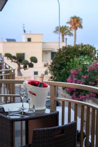 a table with two wine glasses on a balcony at Una rosa sul mare Monopoli in Monopoli
