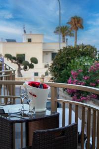 uma mesa com dois copos e um balde em uma varanda em Una rosa sul mare Monopoli em Monopoli