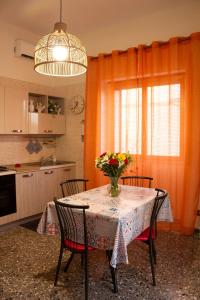 uma cozinha com uma mesa com um vaso de flores sobre ela em Una rosa sul mare Monopoli em Monopoli