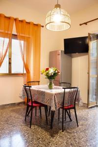 uma mesa de jantar com cadeiras e um vaso de flores em Una rosa sul mare Monopoli em Monopoli